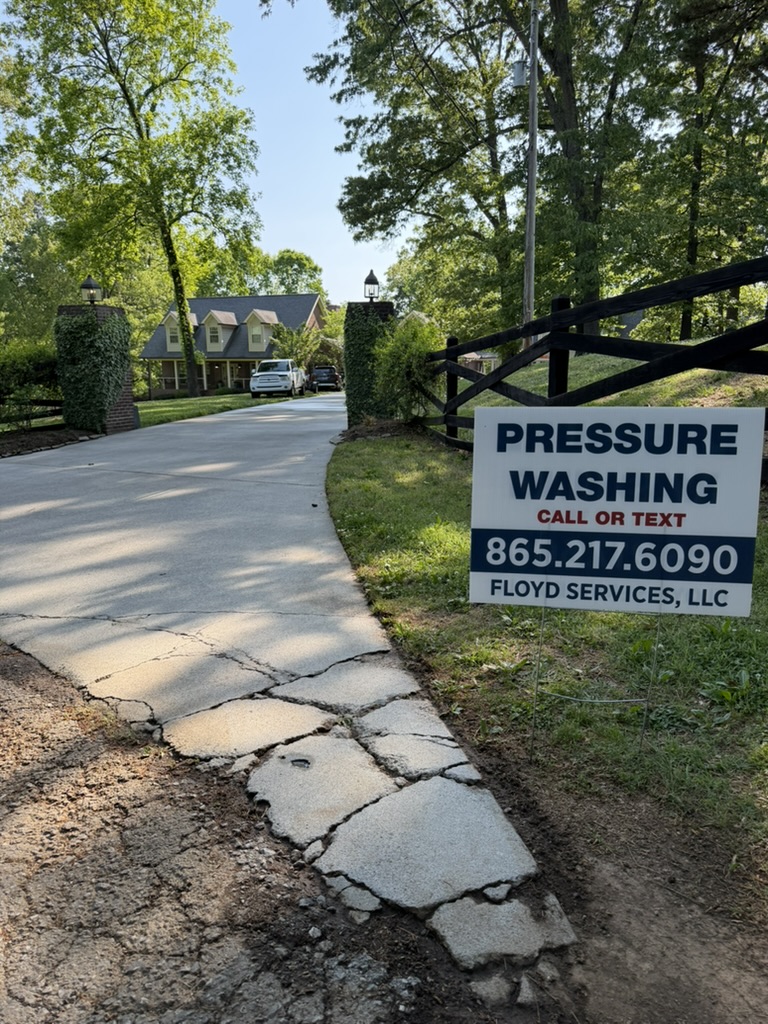 Freshly pressure washed concrete driveway with Floyd's Services yard sign