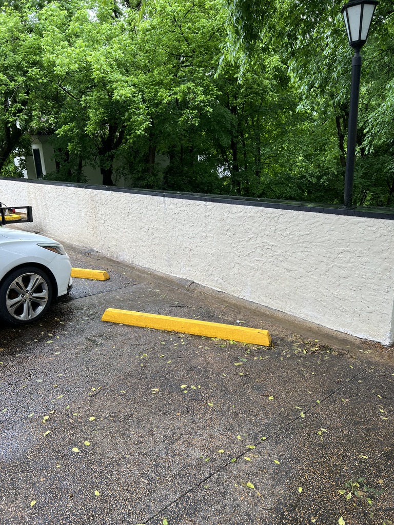 Clean stucco wall with parking bumpers restored after washing